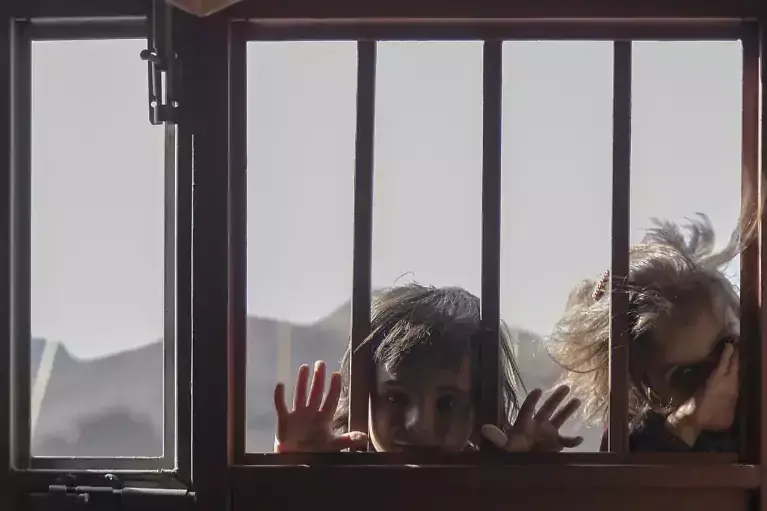 enfants regardant à travers une fenêtre